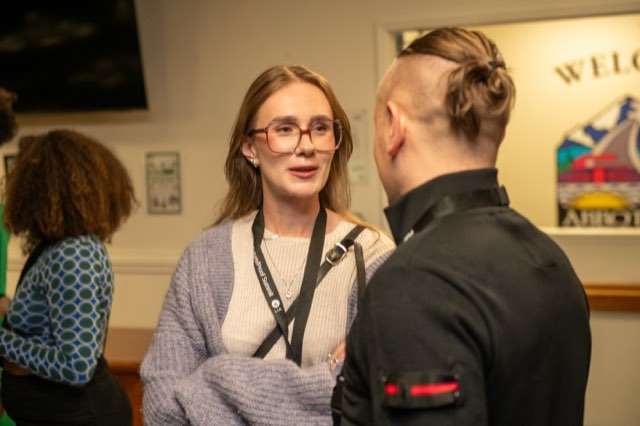 An attendee in conversation near the welcome sign at the Future Proof Creator Summit 2026