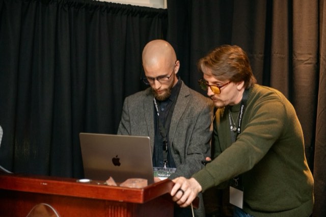 Two attendees looking at a laptop together backstage at the Future Proof Creator Summit 2026