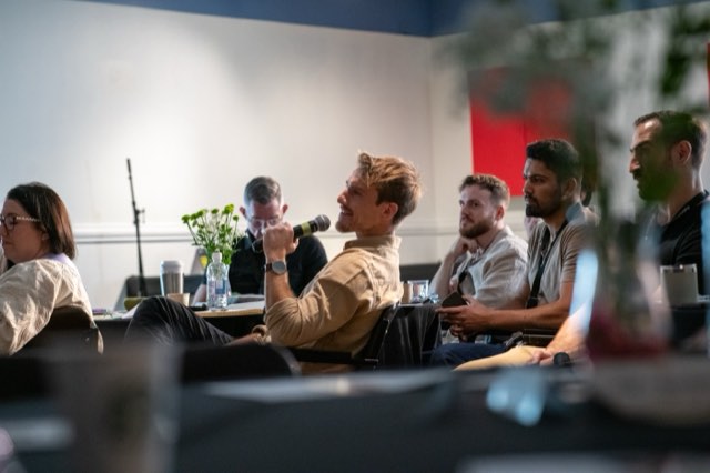 A speaker addressing the room with a microphone at the Future Proof Creator Summit 2026
