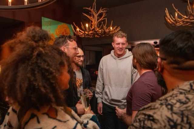 Attendees talking with Dan Koe at the VIP Dinner