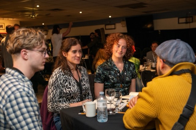 A group of attendees in conversation at a table during the Future Proof Creator Summit 2026
